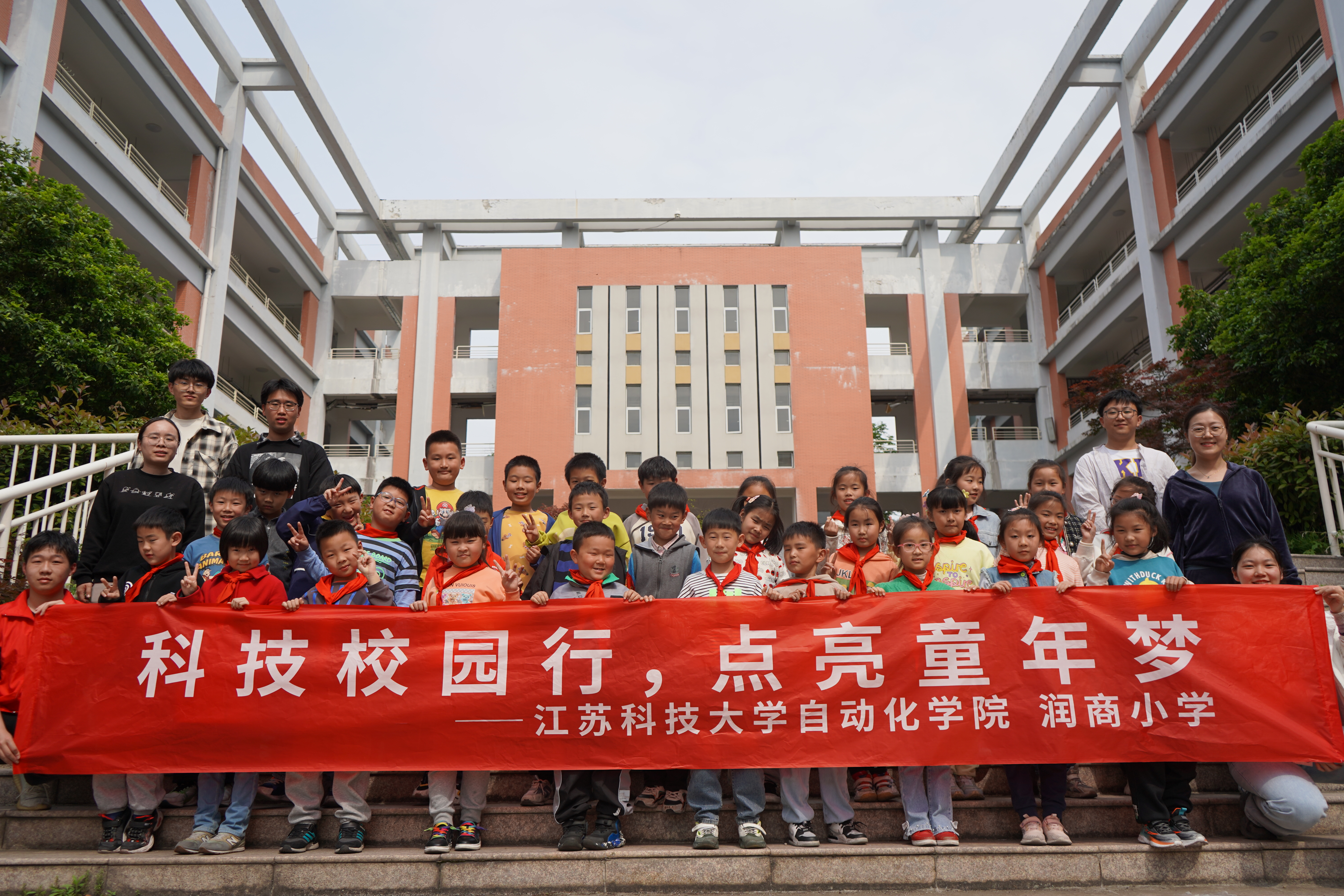 图为新蒲京娱乐场官网3245自动化学院志愿者同镇江市润商小学二年级一班同学拍照合影留念.JPG